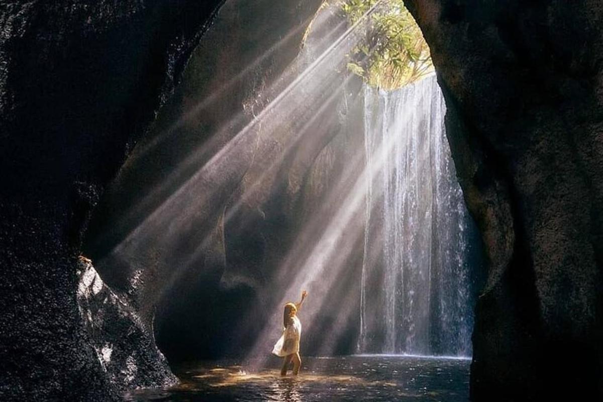 a woman standing in front of a waterfall