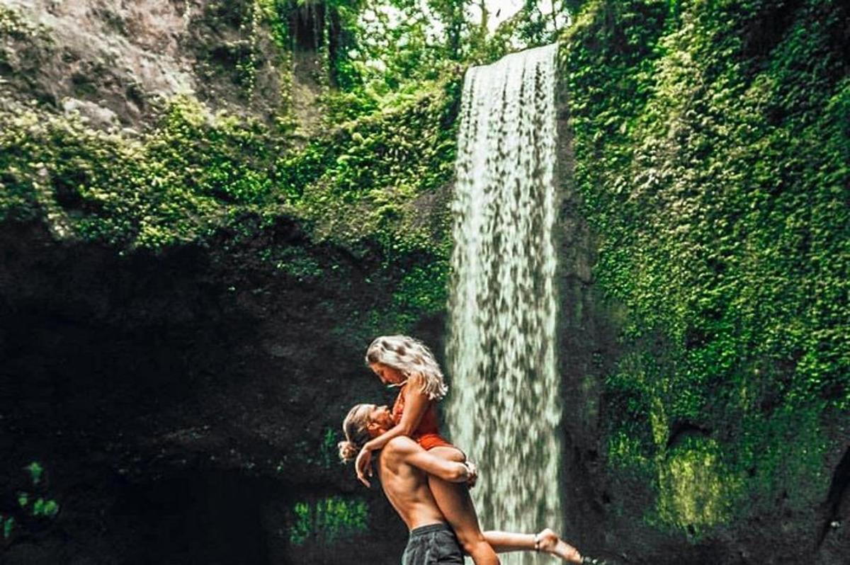 een schilderij van een vrouw die naast een waterval zit