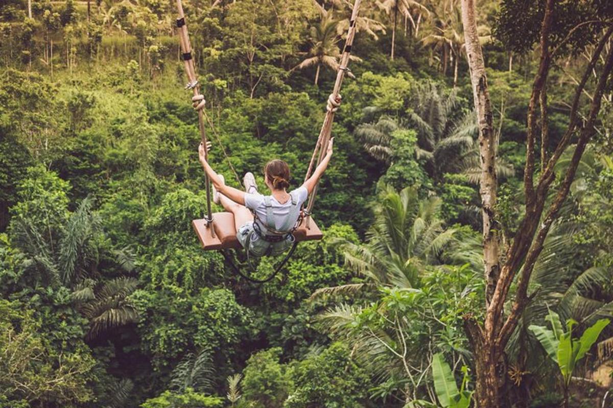 a woman swinging on a rope swing in the jungle