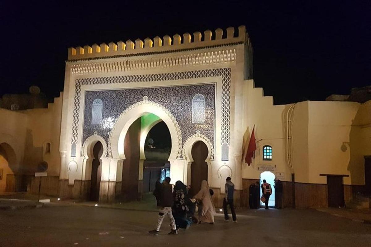 a group of people walking in front of a building at night