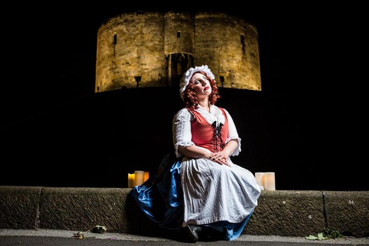a woman sitting on a wall in front of a building