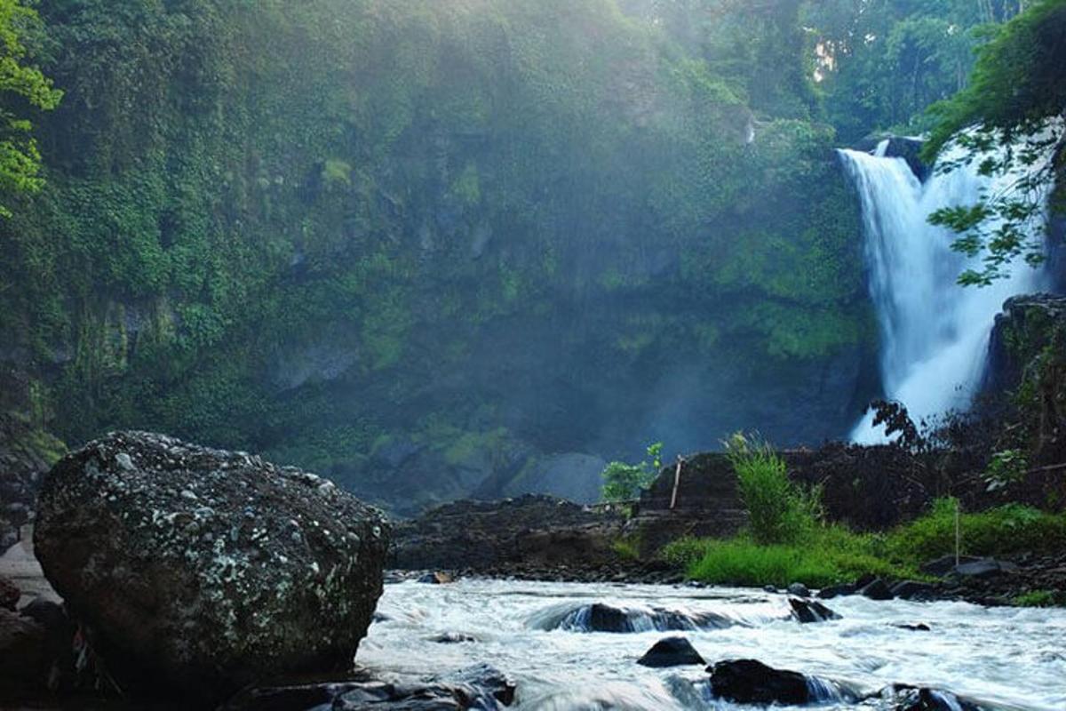 een waterval in het midden van een rivier met een rots