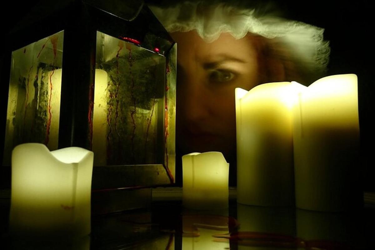 a woman looking at her face in a mirror with candles