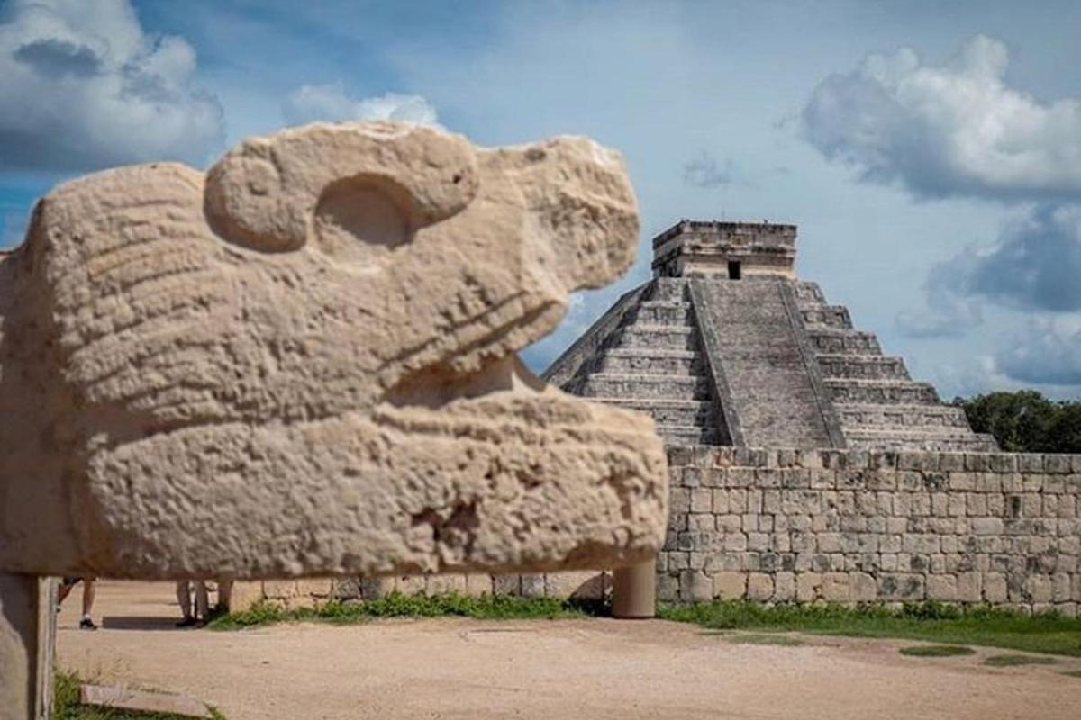 uma grande estátua de leão de pedra em frente a uma pirâmide