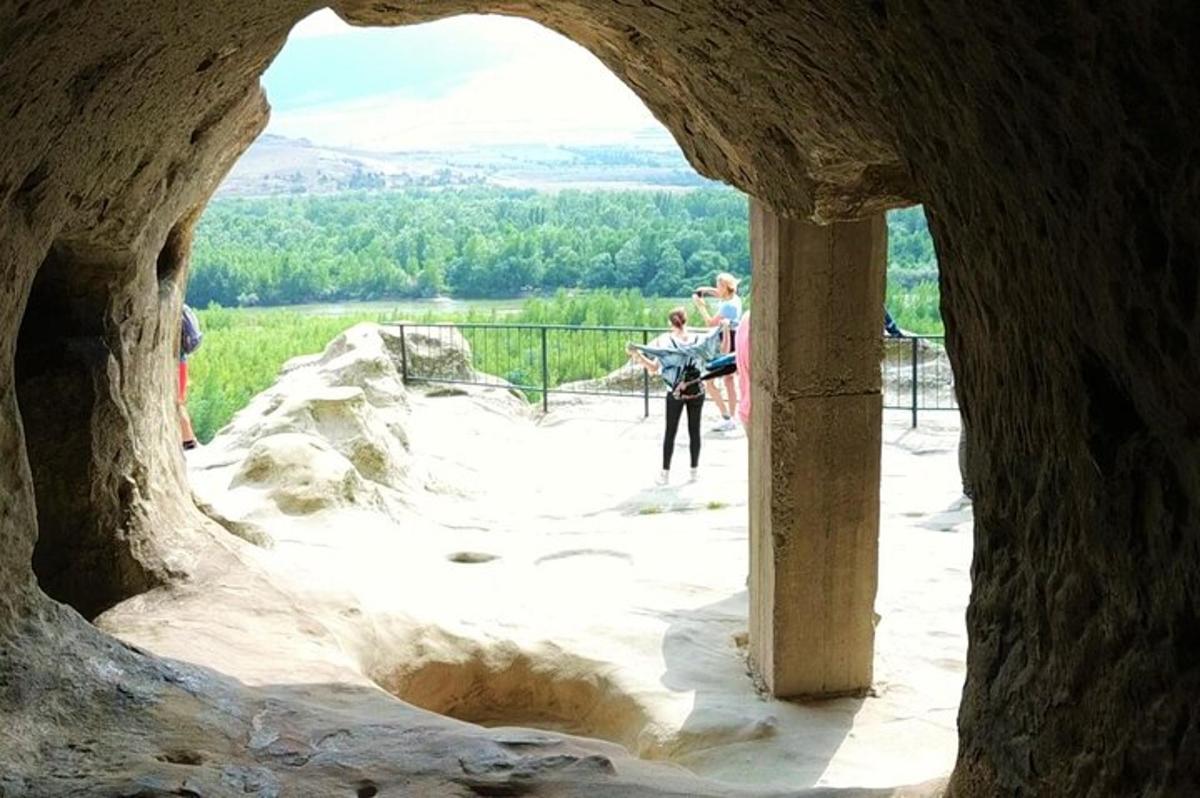 Un grupo de personas de pie en un arco de piedra.