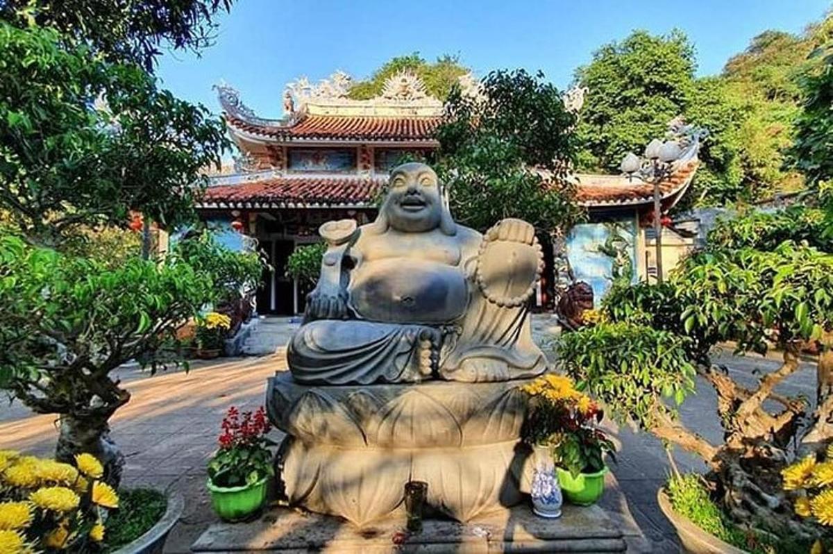 uma grande estátua em um jardim em frente a um prédio