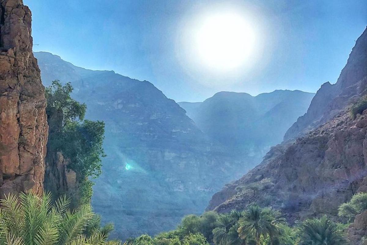 a view of a canyon with the sun in the sky