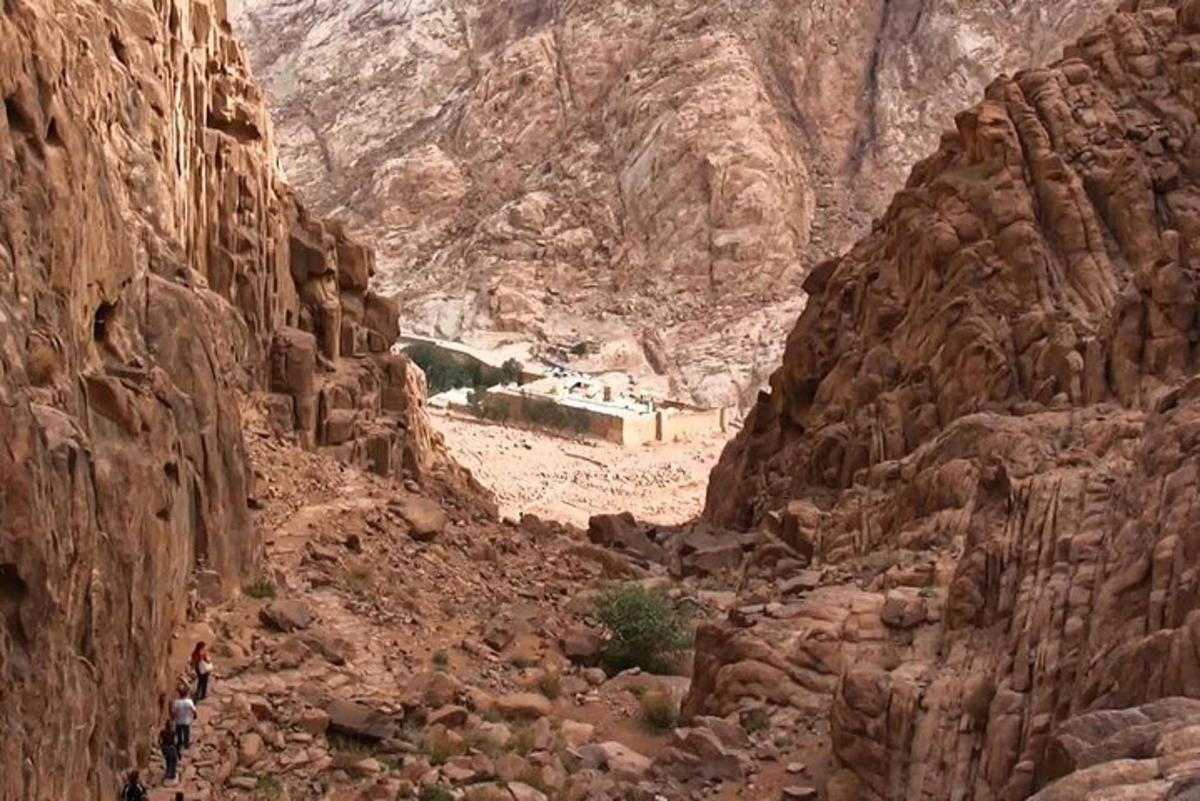 a group of people walking through a rocky canyon