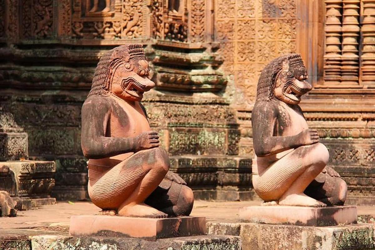 Dos estatuas están sentadas frente a un edificio.