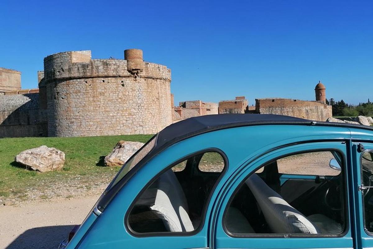 a blue car parked in front of a castle