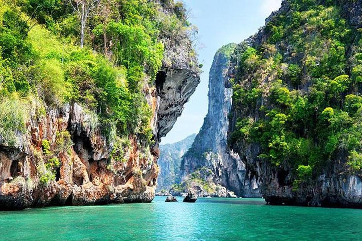 a group of boats in the water between two cliffs