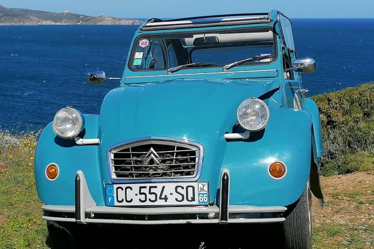 a blue truck parked next to the ocean
