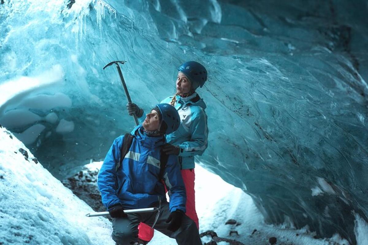 two people standing in front of an ice cave