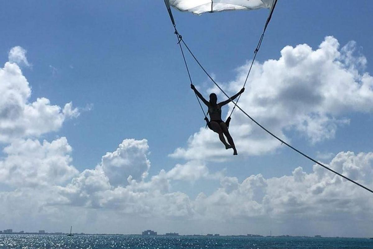 a person is hanging on a rope over the ocean