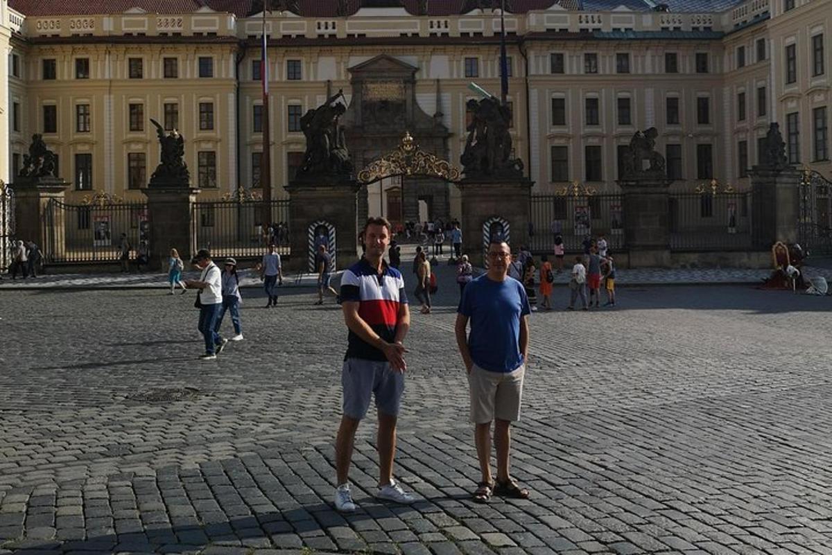 Dos hombres de pie frente a un gran edificio.