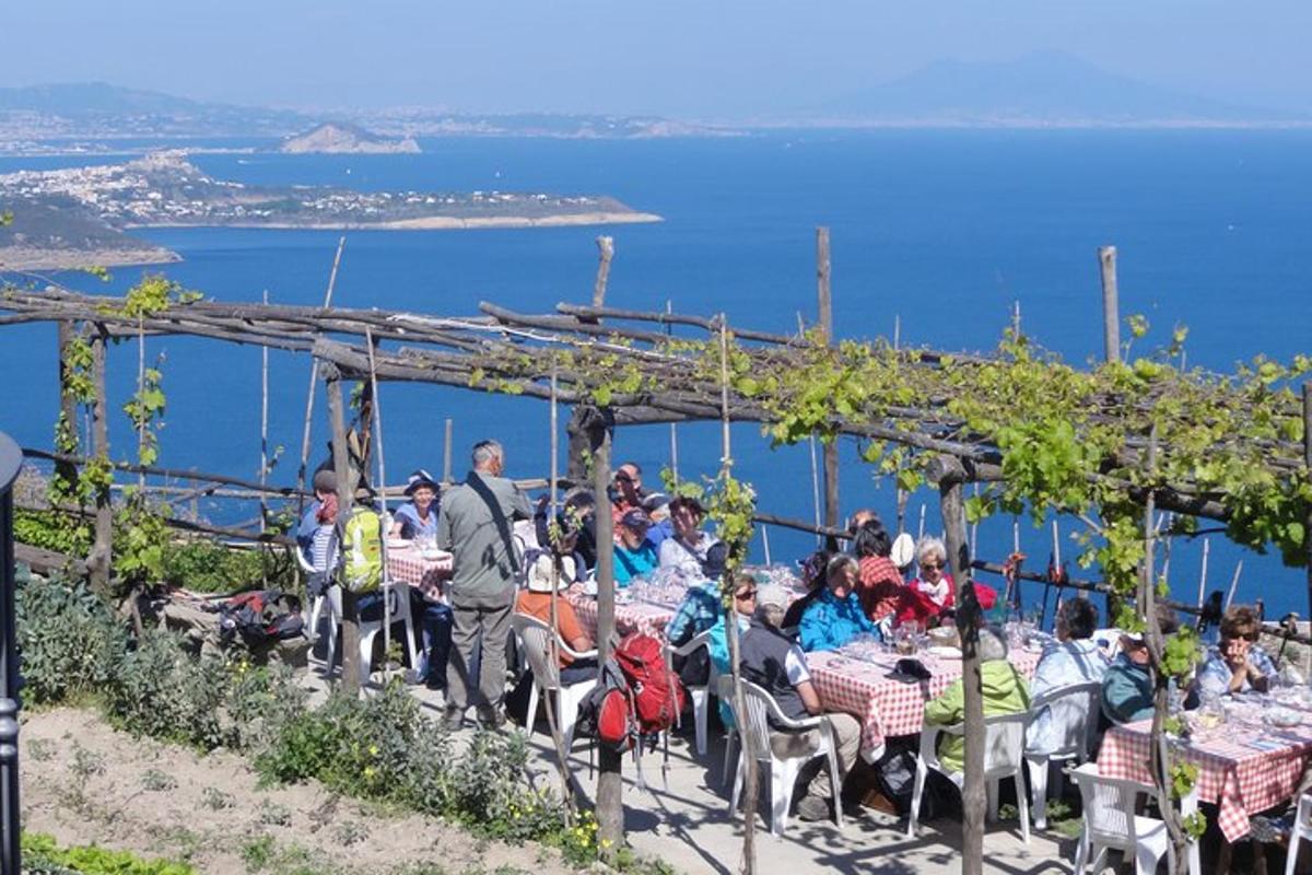 μια ομάδα ανθρώπων που κάθονται σε τραπέζια με φόντο τον ωκεανό