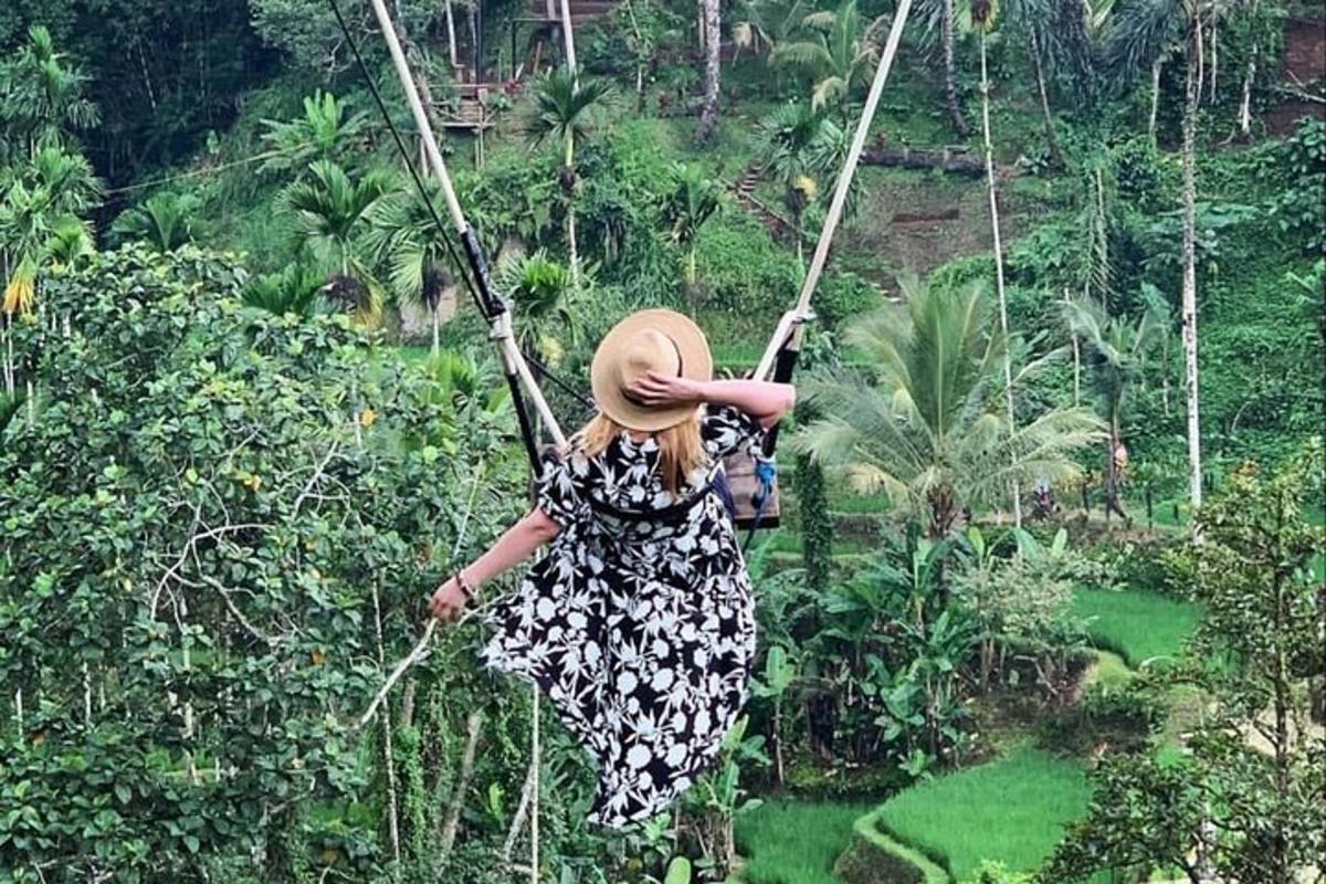 une femme se balançant sur une balançoire en corde dans une forêt