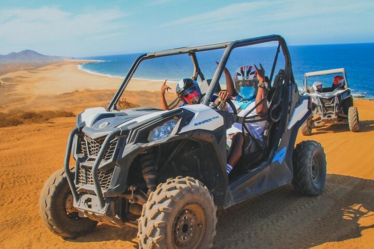 um grupo de pessoas em um quadriciclo na praia