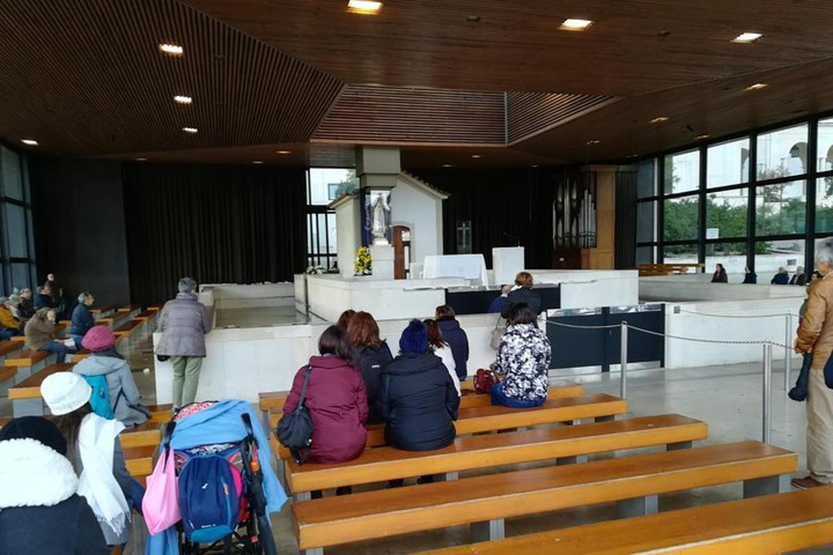 egy csoport ember ül padokon egy templomban