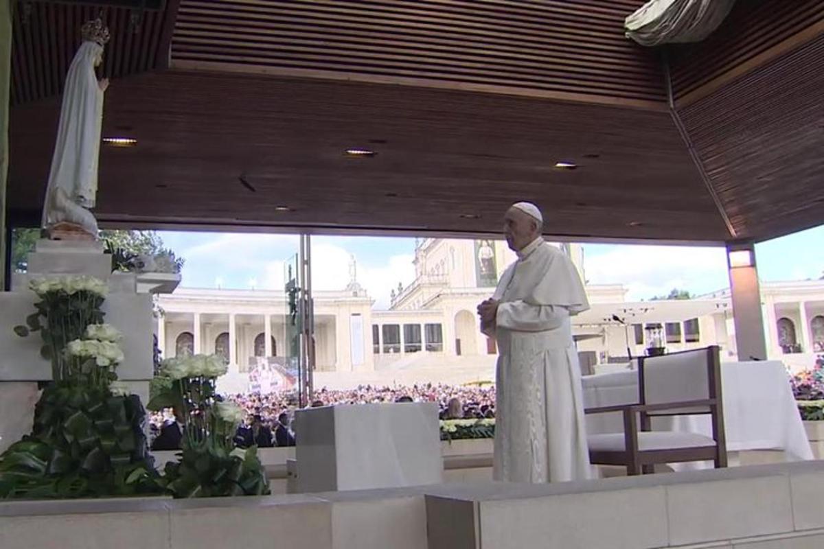 un home religiós dempeus davant d'un edifici