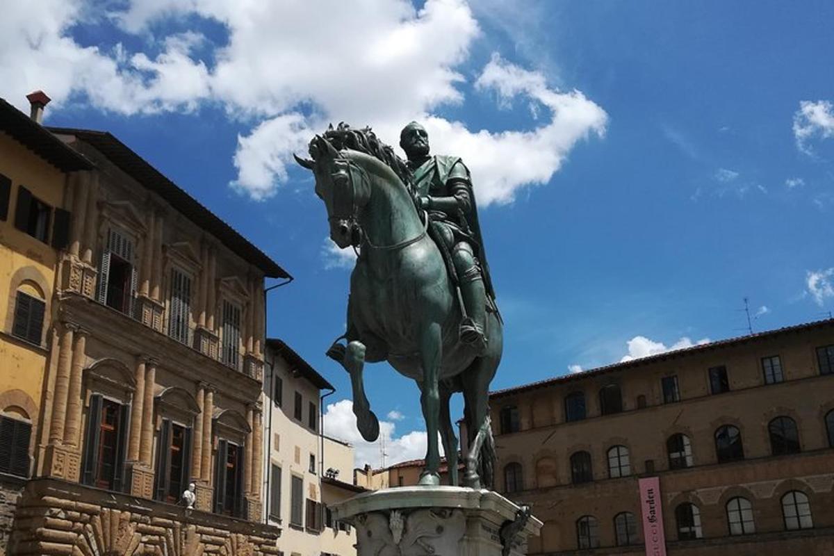 en statue af en mand, der rider på en hest, foran en bygning