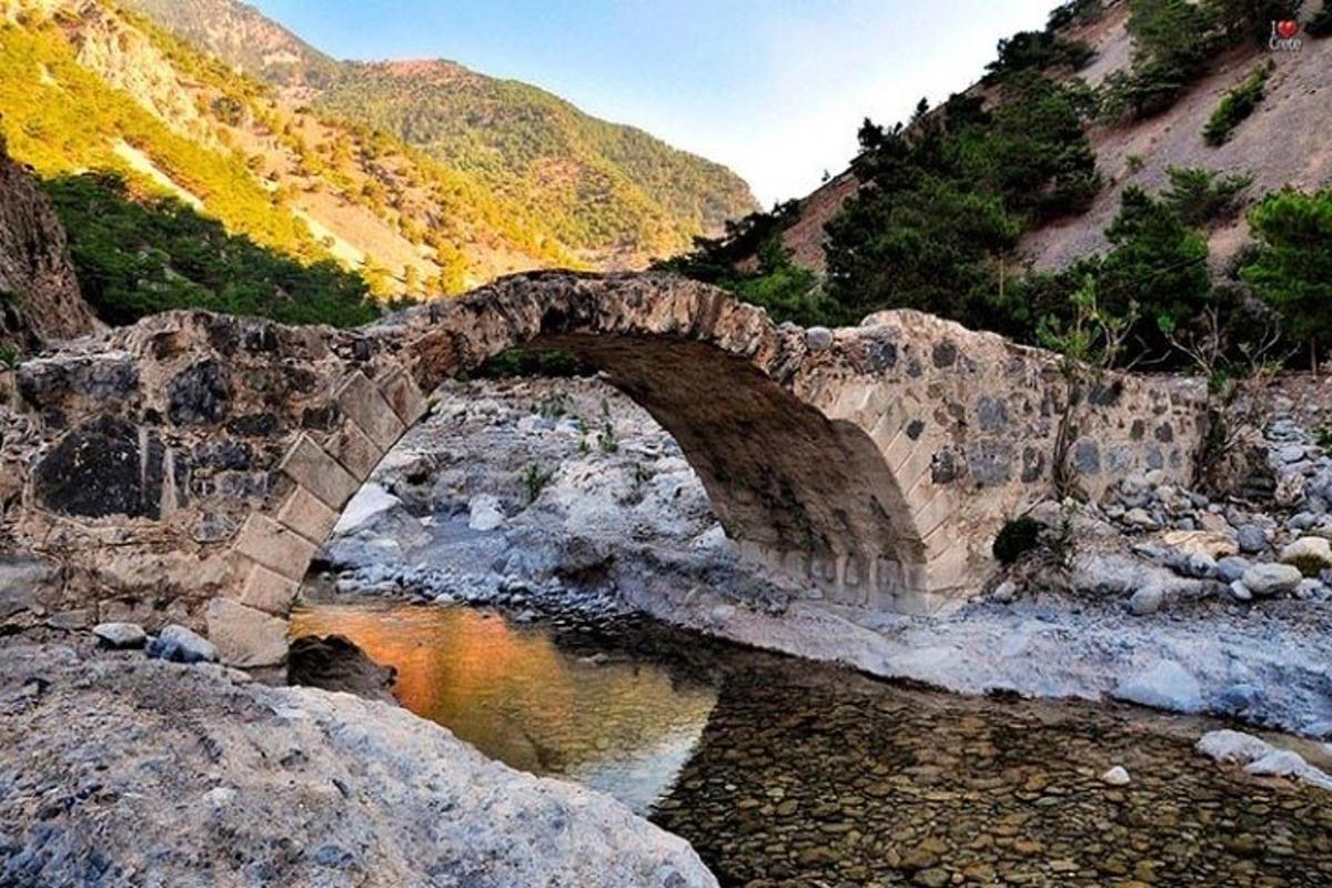 eine Steinbrücke über einen Fluss in einem Berg