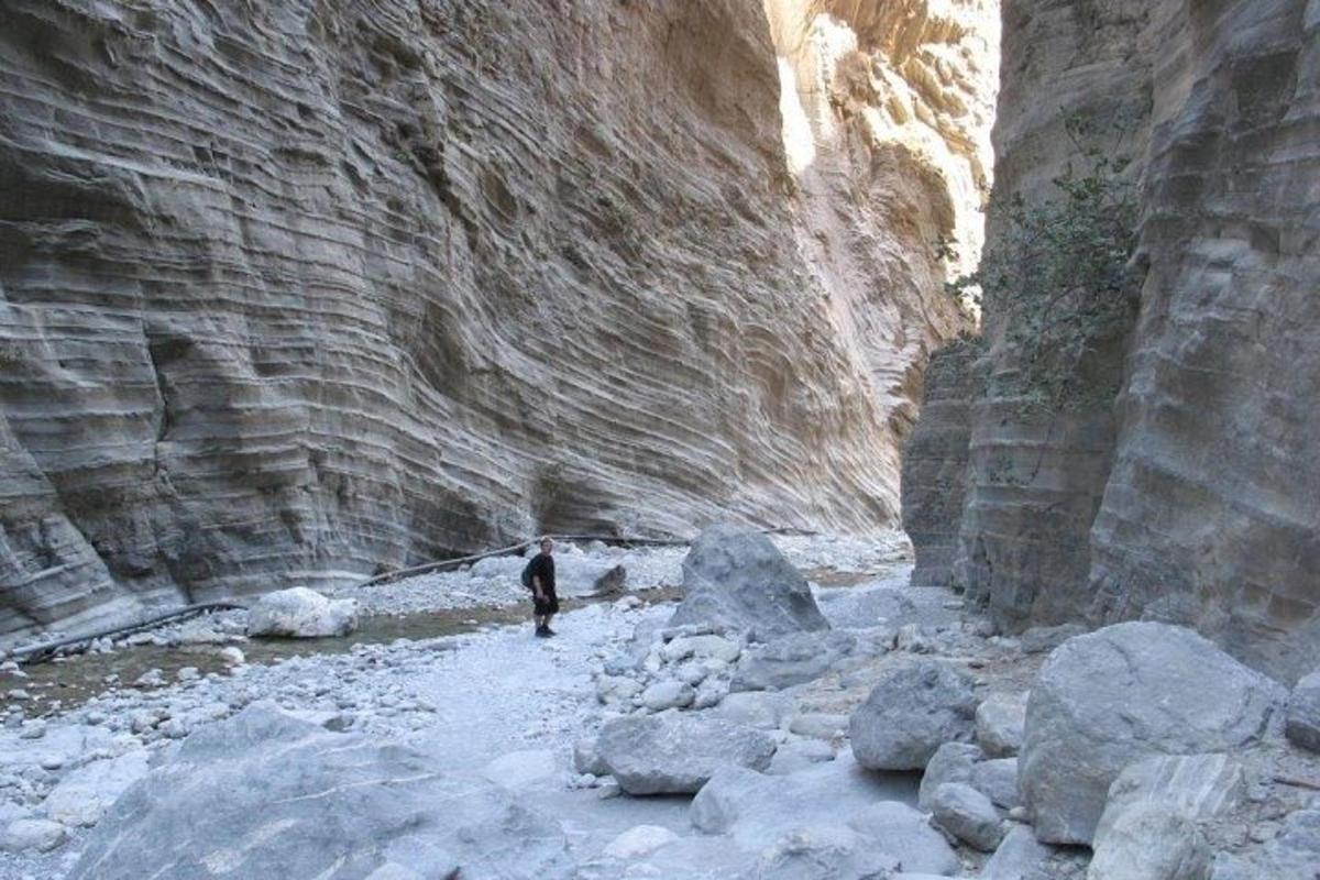 eine Person geht durch eine Schlucht mit Felsen