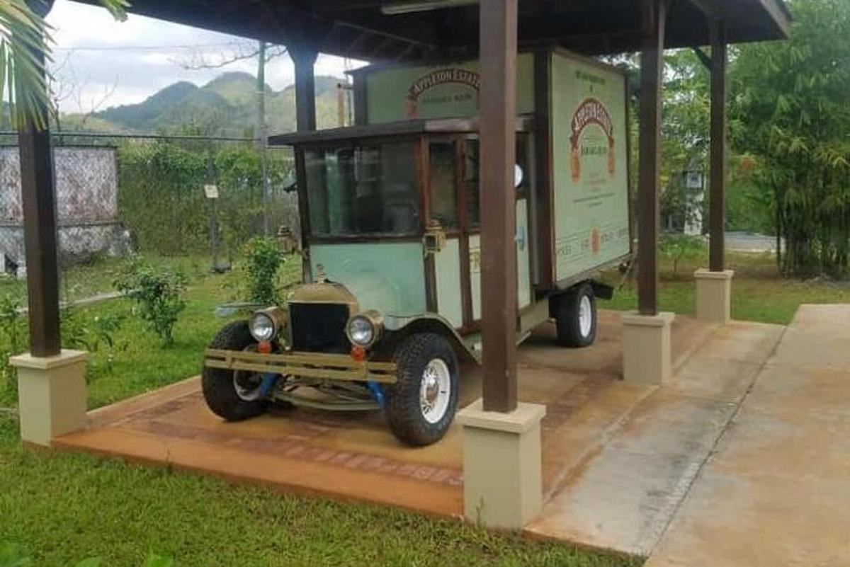 Un coche viejo está aparcado bajo un refugio.