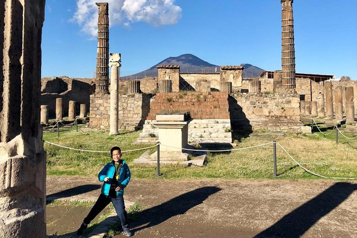 una donna che cammina davanti a delle antiche rovine