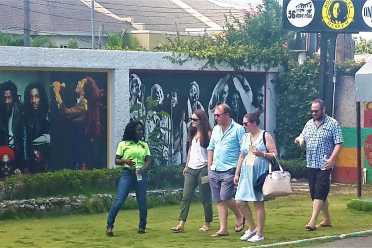 a group of people walking in front of a mural
