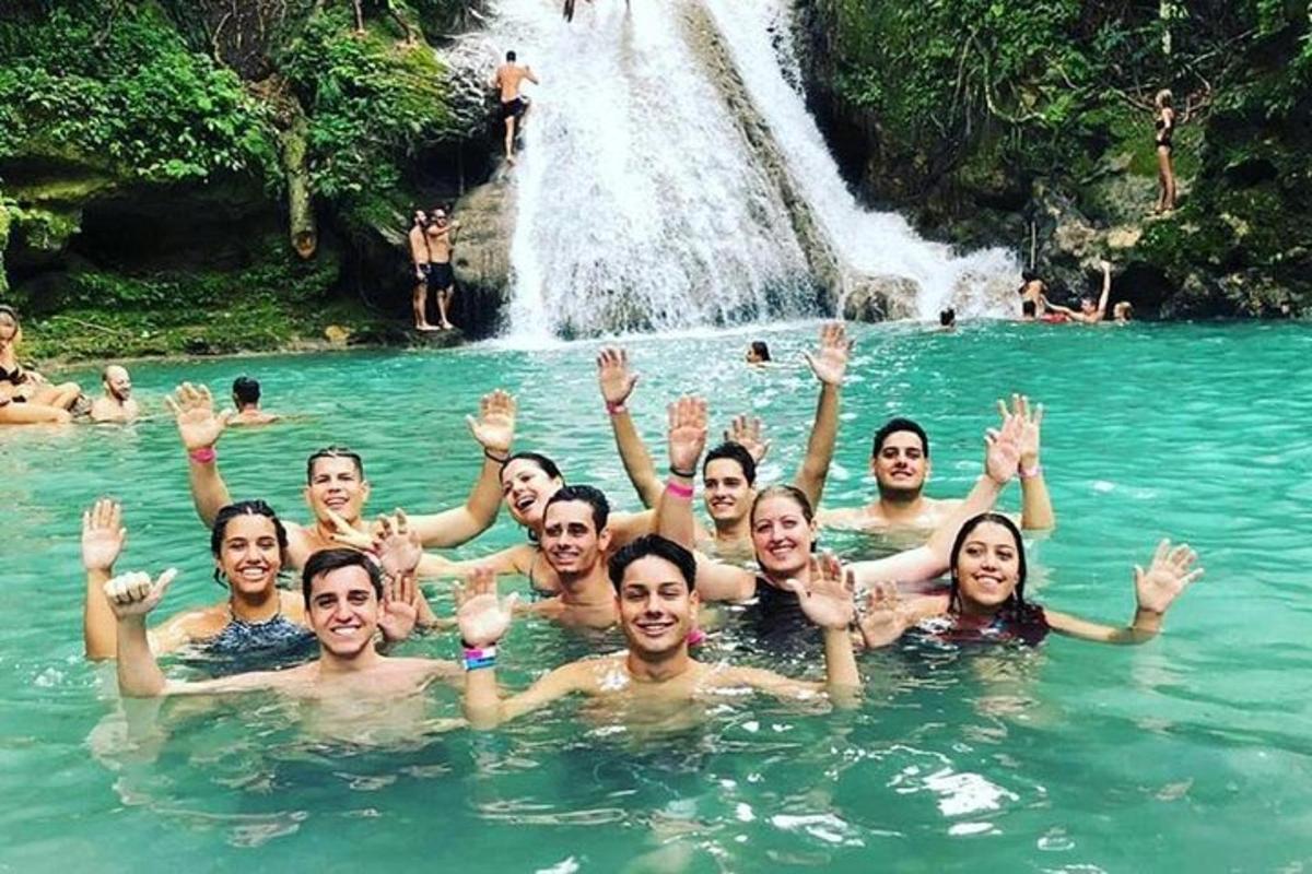 un grup de persones nedant a l'aigua davant d'una cascada