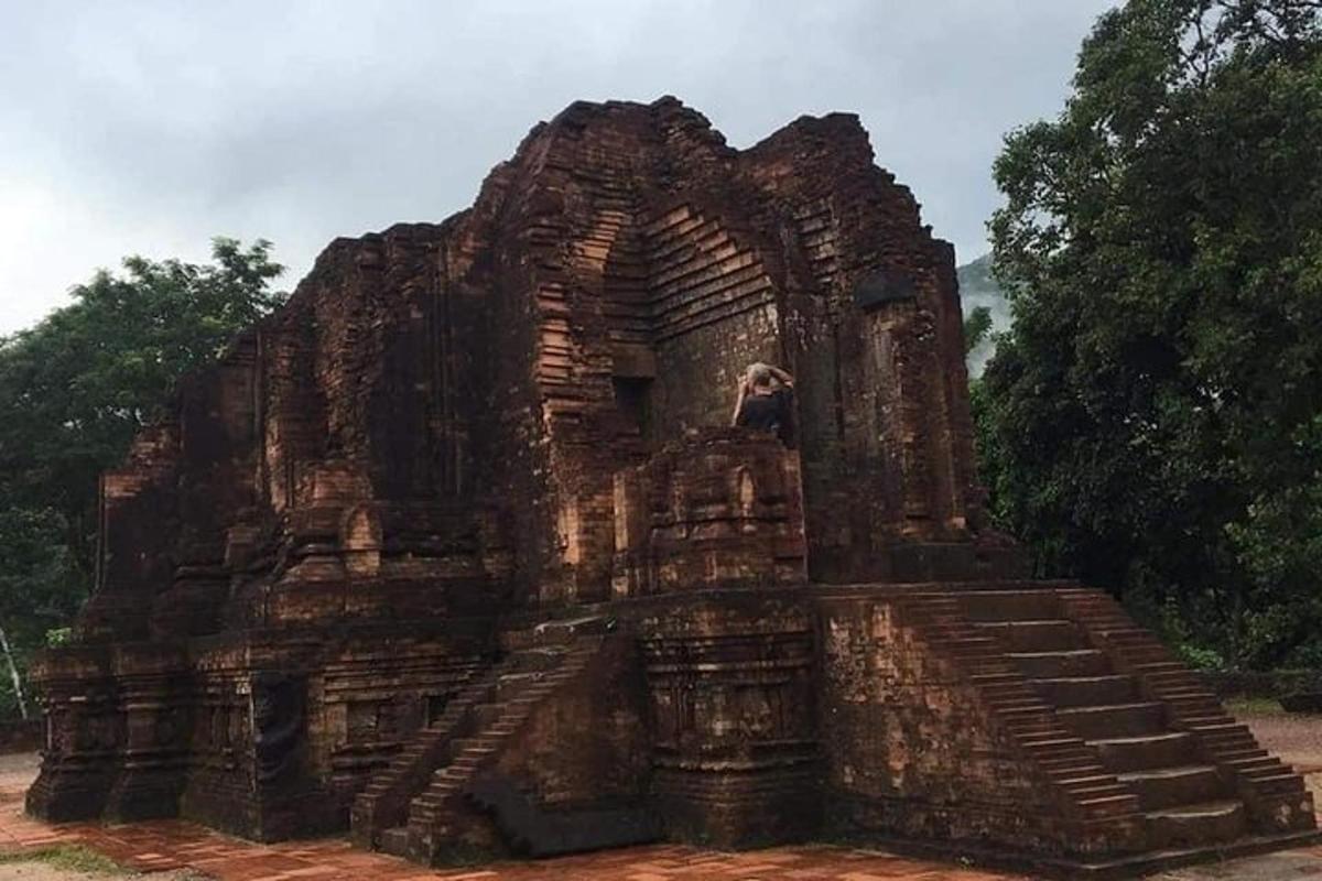 Un gran edificio de piedra con una persona parada sobre él.