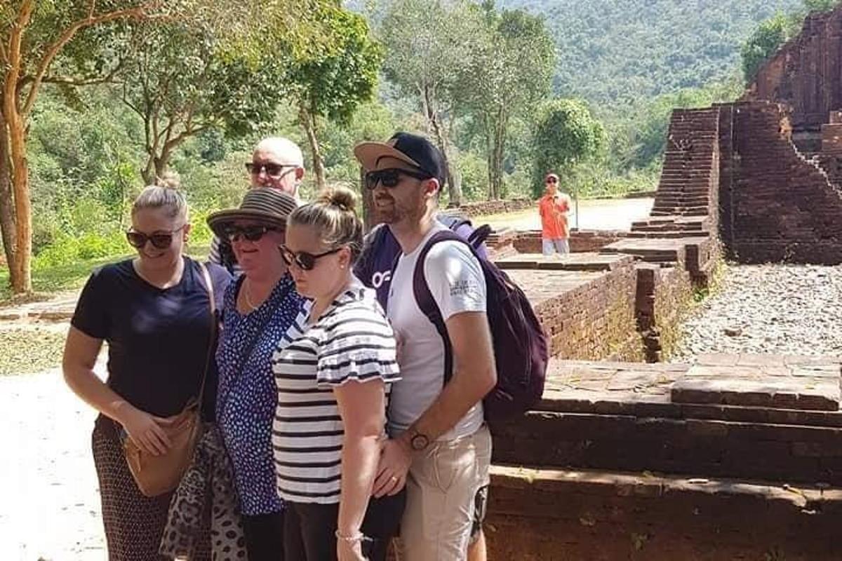un gruppo di persone in piedi davanti a una rovina