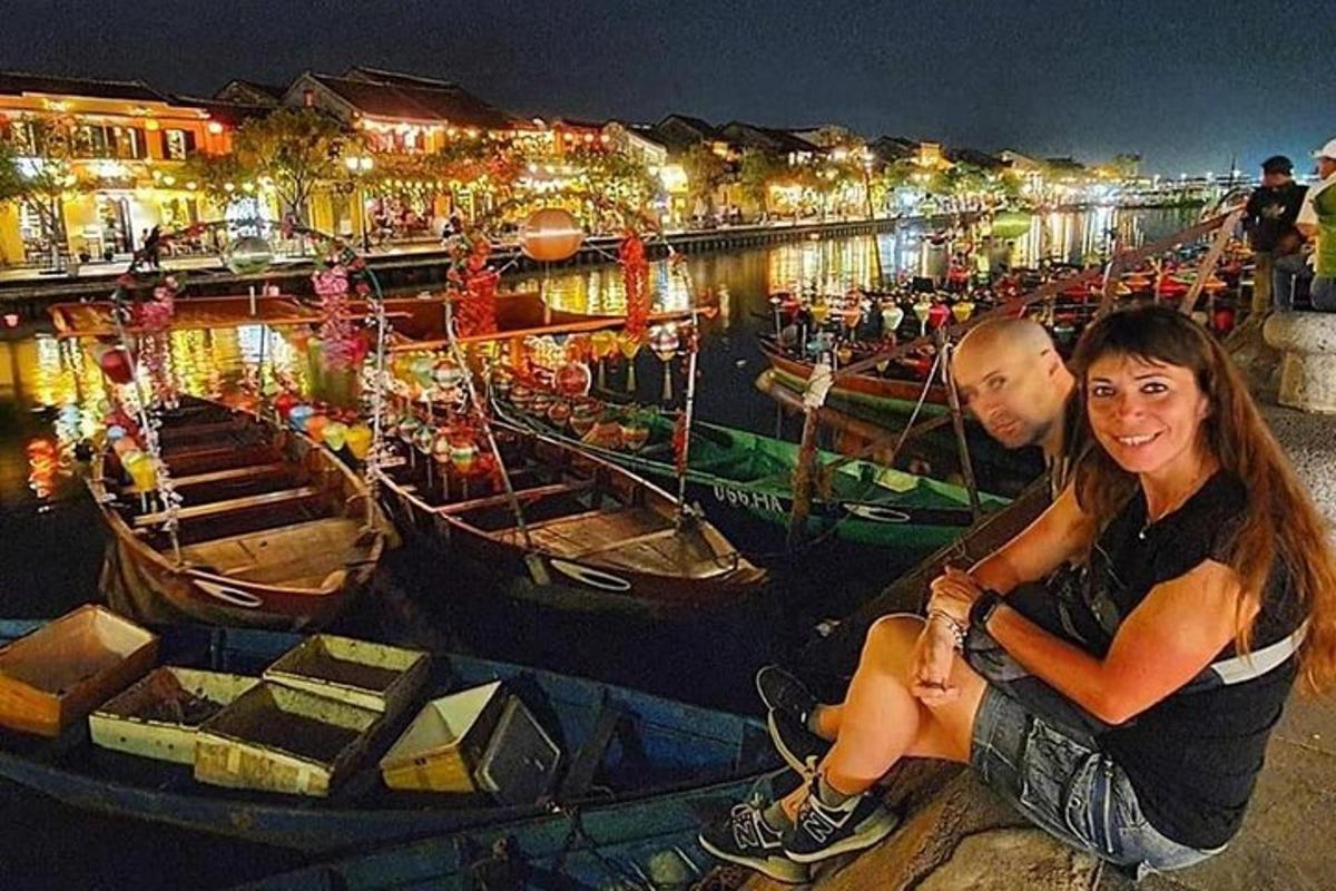 muž a žena sedící na molu poblíž lodí