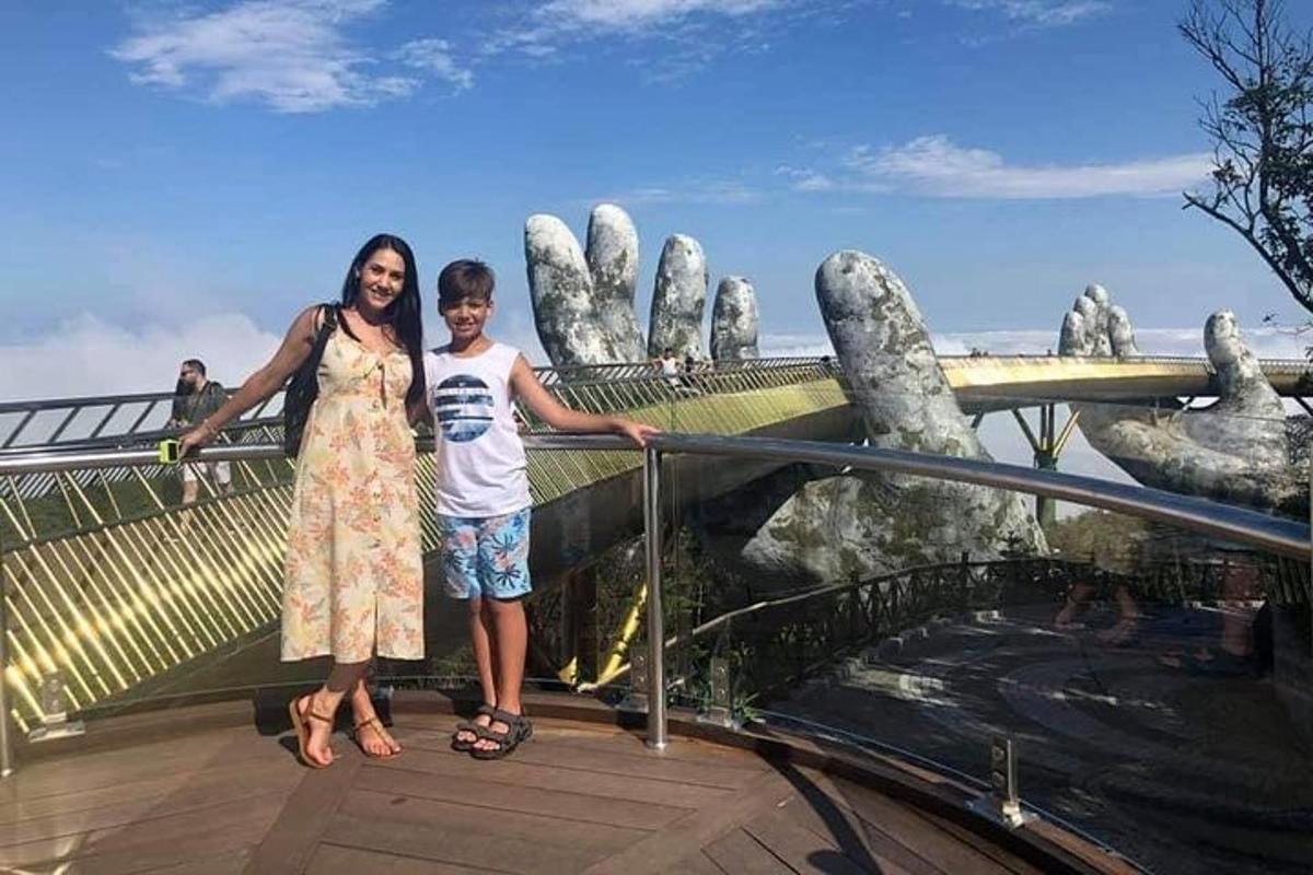une femme et un jeune garçon debout sur une passerelle devant une main