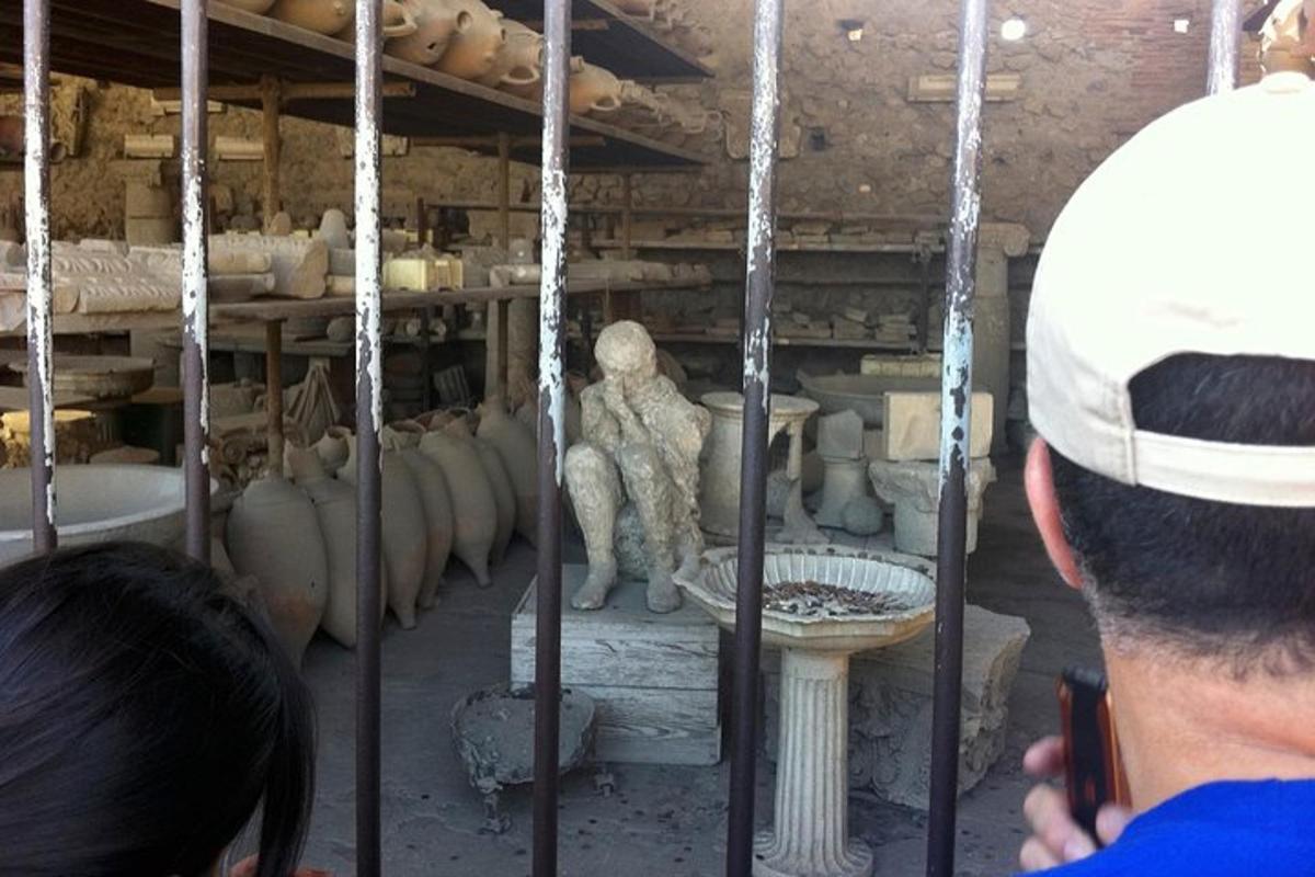 Un hombre tomando una fotografía de una estatua en un museo.