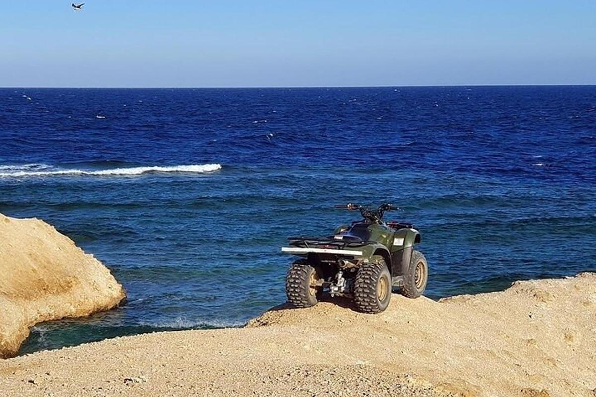 czterokołowy pojazd zaparkowany na plaży w pobliżu oceanu