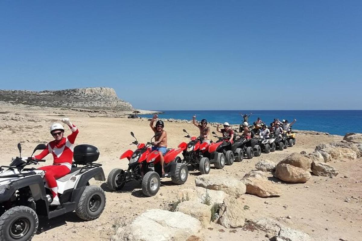 Grupa ludzi jeżdżących na quadach po plaży
