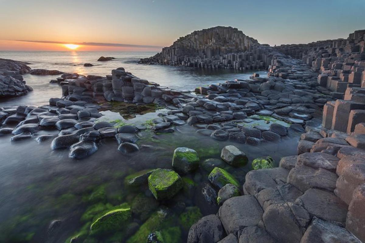 an aerial view of a rocky beach at sunset