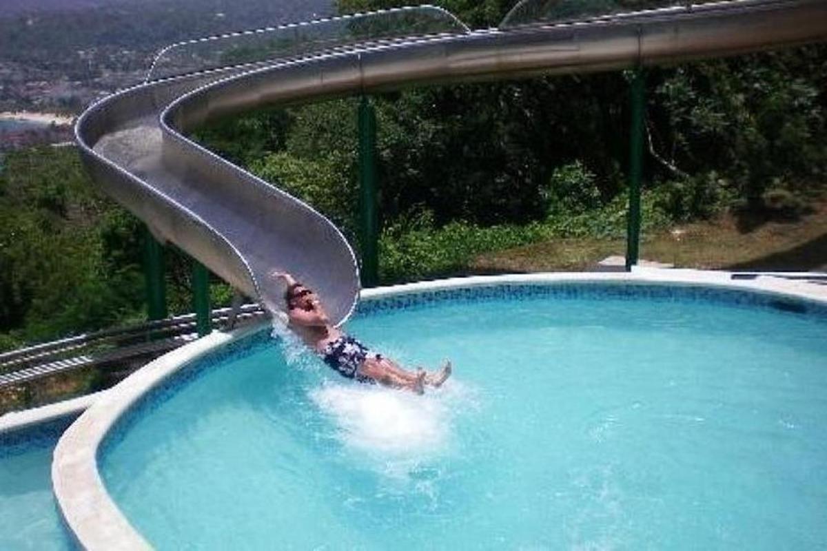 un uomo è in piscina su uno scivolo d'acqua