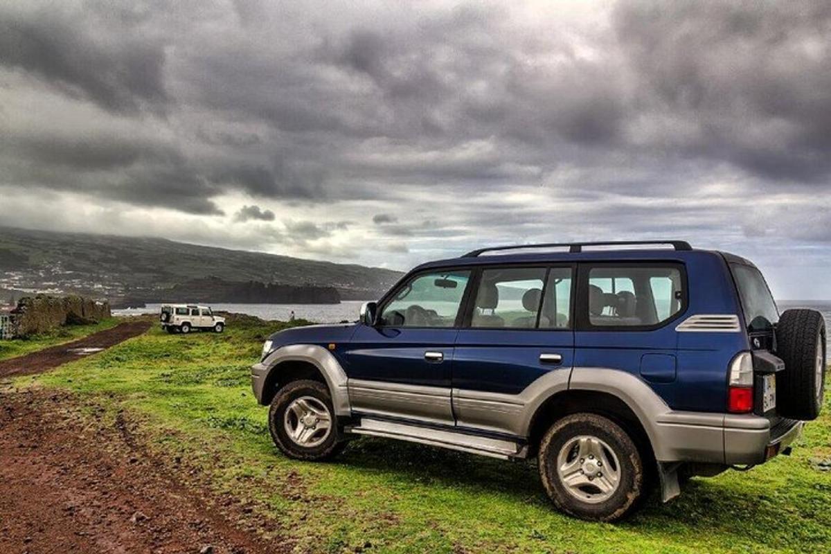 una jeep blu parcheggiata sul ciglio di una strada sterrata