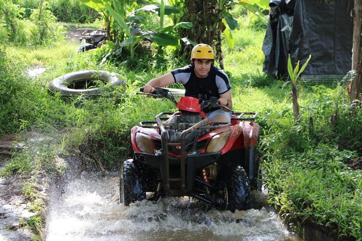 a man riding a four wheeler through the water