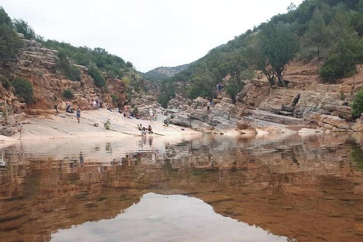 una massa d'aigua amb gent caminant per la platja