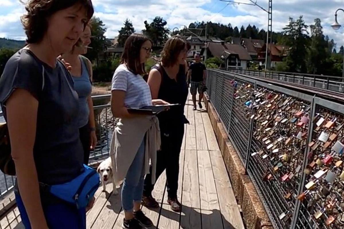 skupina žen stojící na mostě se psem