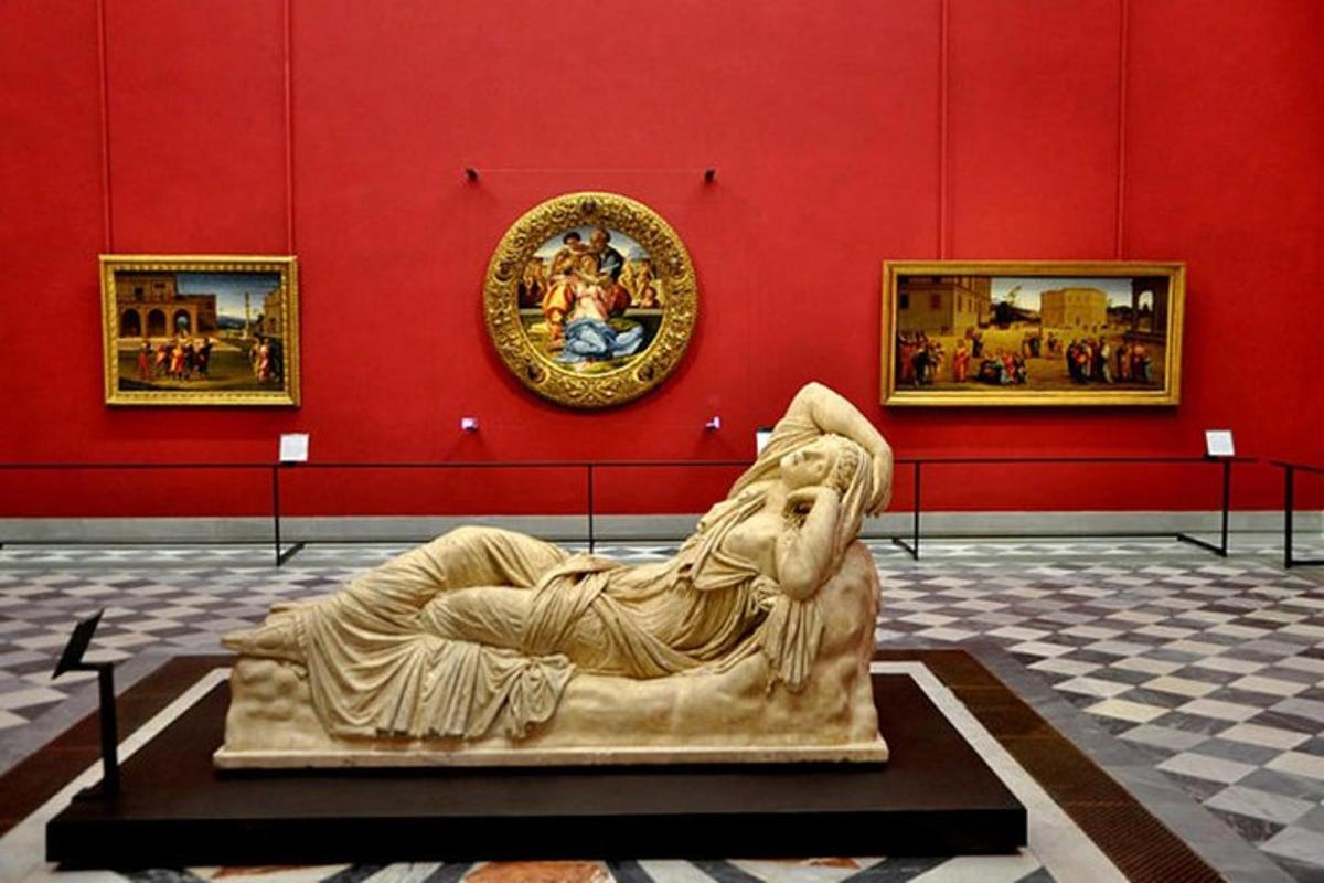 uma estátua em uma sala com uma parede vermelha