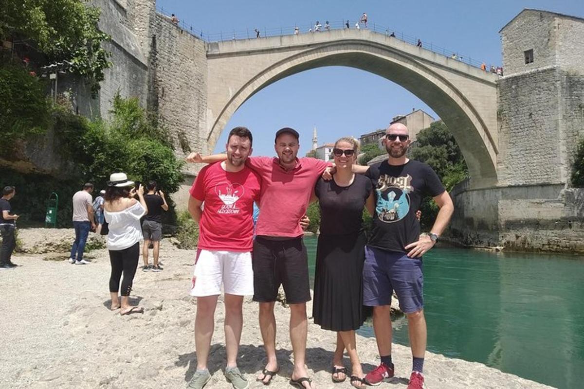Un grupo de personas de pie frente a un puente
