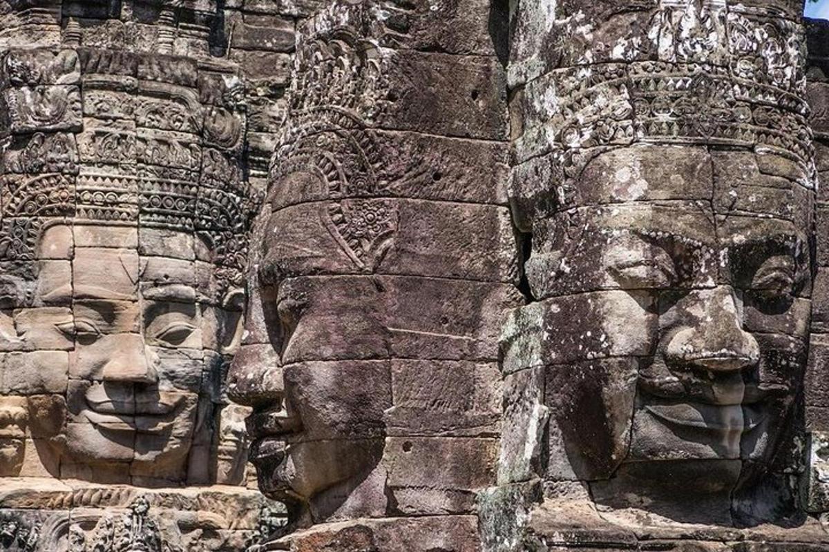 dues cares de pedra al costat d'una paret de pedra