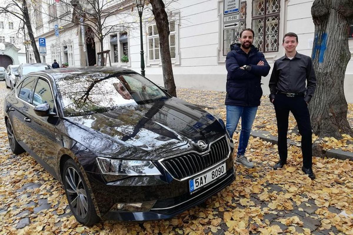 dvaja muži stojaci vedľa auta v listoch