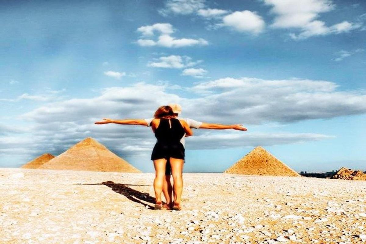 žena stojící před pyramidami