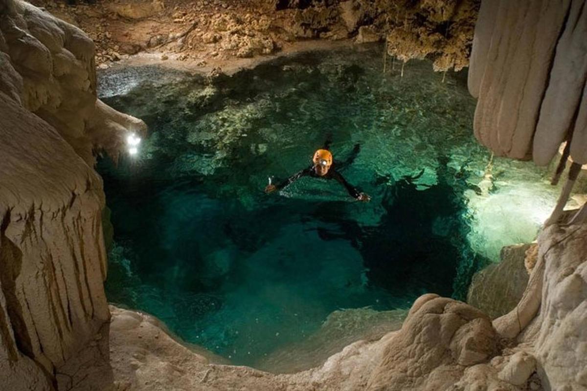 un uomo che galleggia in una pozza d'acqua in una grotta